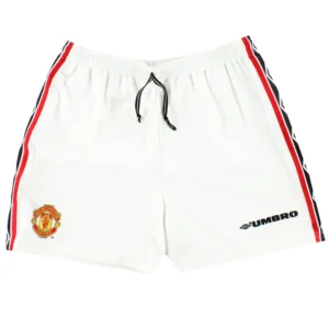 White Manchester United retro shorts with an embroidered club crest and red/black side trim, featuring a black drawstring and Umbro logo.